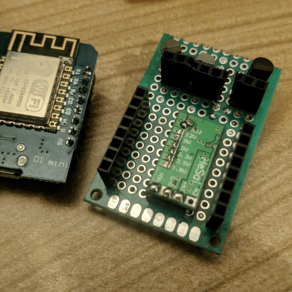 Headers and the buck converter Component side of the perfboard with female headers and the buck converter soldered flat, next to a Wemos D1 mini